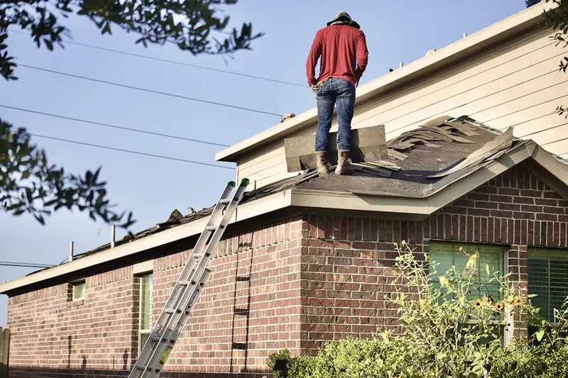 Professional roofer working on a residential roof in Woodland Village
